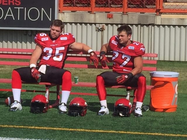 two football players on bench