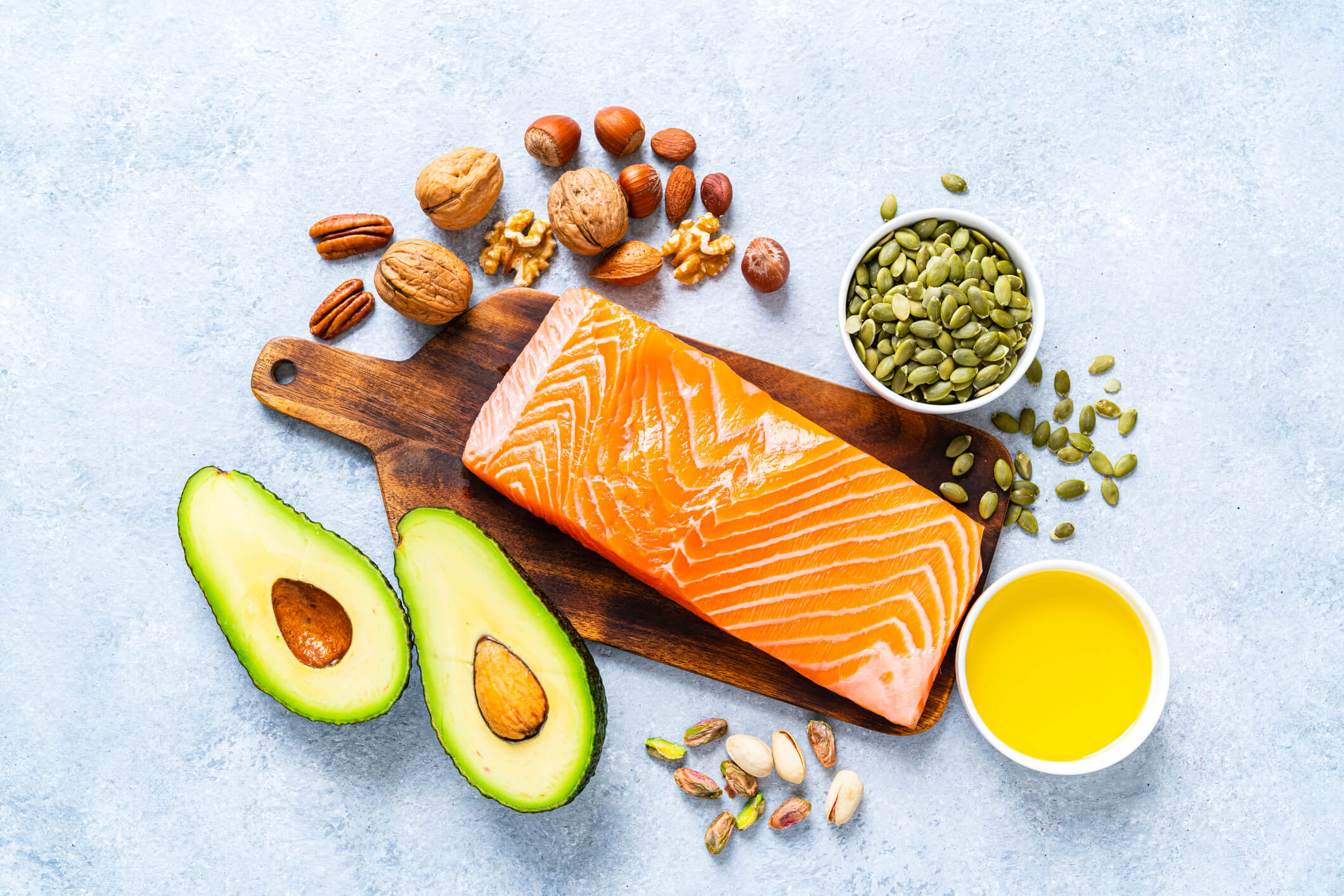 A collection of foods rich in healthy fats, including salmon, avocado, and nuts.