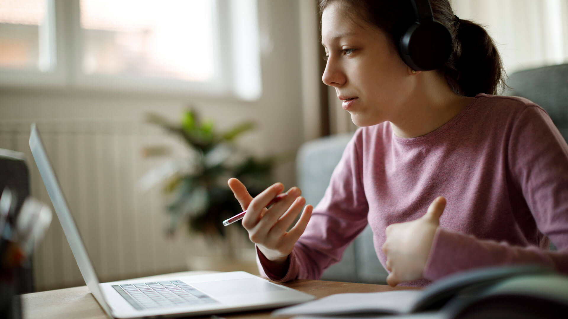 teen using a laptop wearing headphones