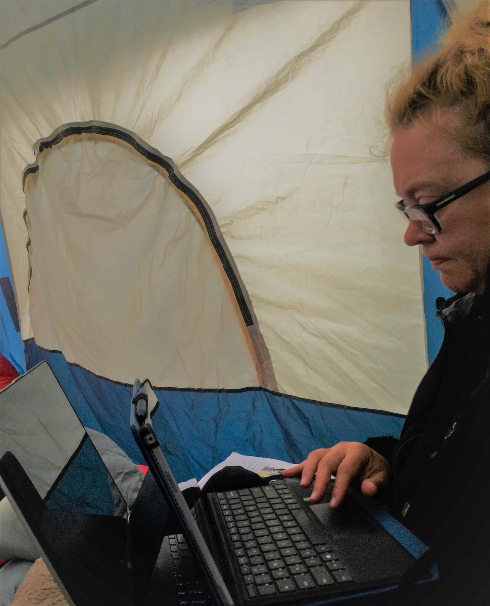 Uilani Ballay studying in a tent with two laptop computers