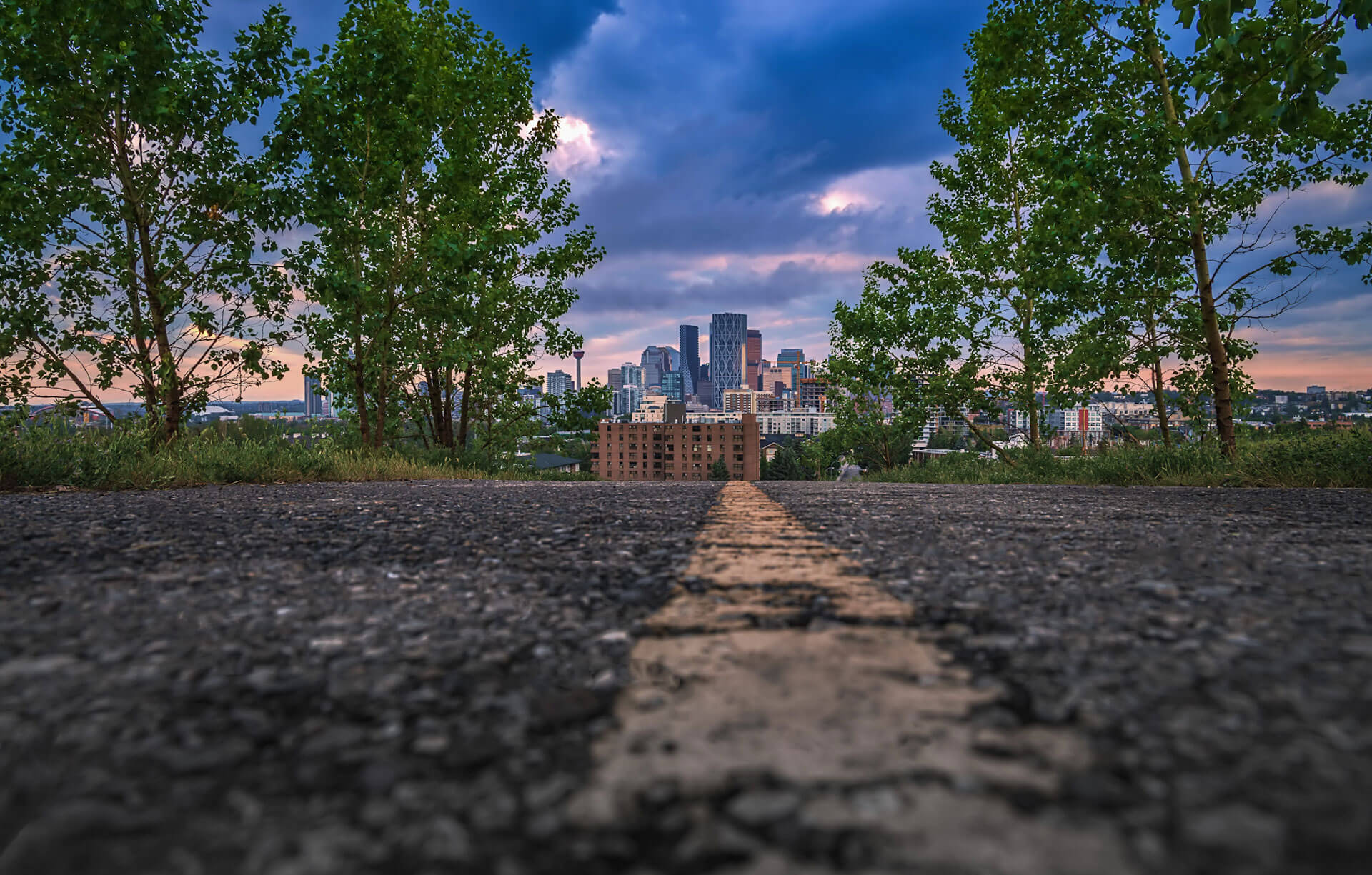 a low-angle shot of a road leading to downtown Calgary