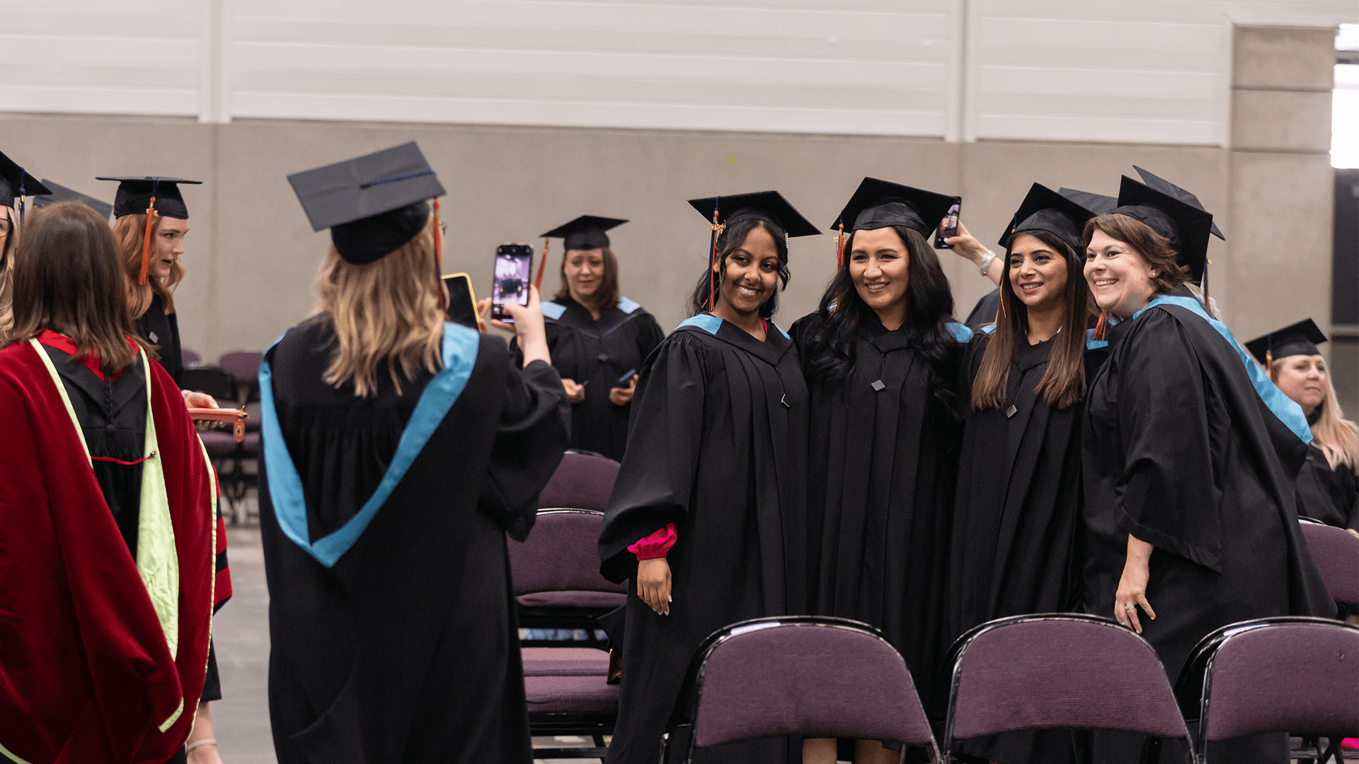 graduate taking a photo of four graduates